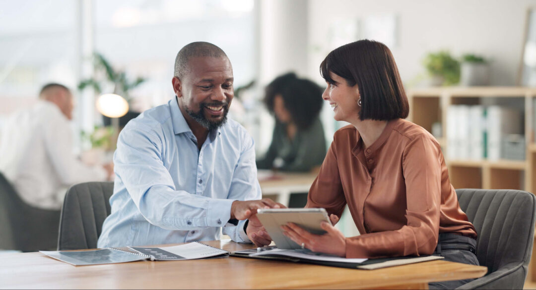 Insurance broker asking a small business client questions to build trust during a benefits meeting